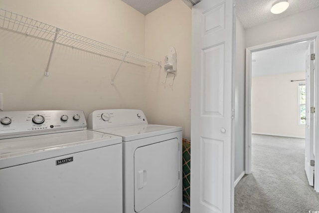 laundry room featuring light carpet, a textured ceiling, and washing machine and dryer