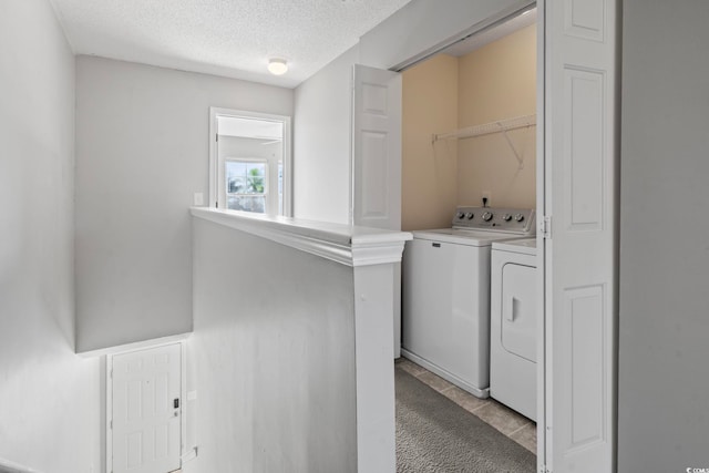 laundry room with a textured ceiling, light carpet, and independent washer and dryer