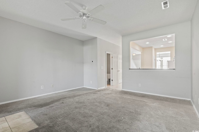 carpeted empty room featuring ceiling fan and a textured ceiling