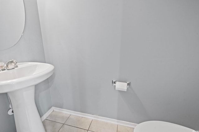 bathroom featuring tile patterned flooring, toilet, and sink