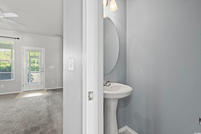 bathroom with ceiling fan, sink, and a textured ceiling