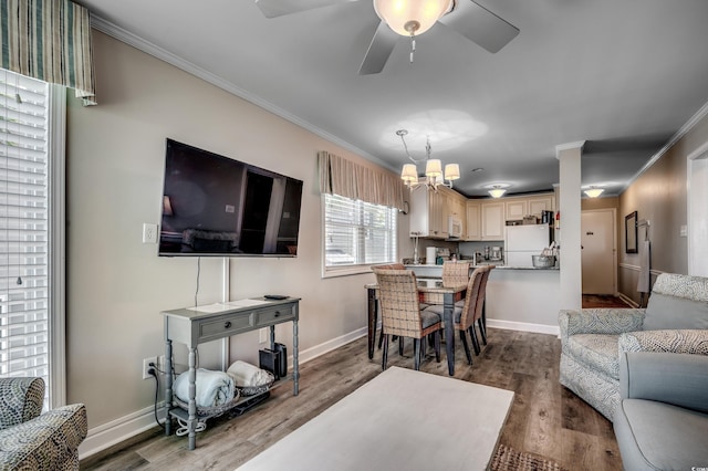 living room featuring ceiling fan with notable chandelier, wood-type flooring, and ornamental molding