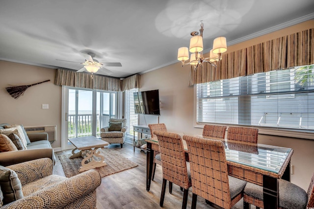 dining area with ceiling fan with notable chandelier, a wall unit AC, hardwood / wood-style flooring, and ornamental molding