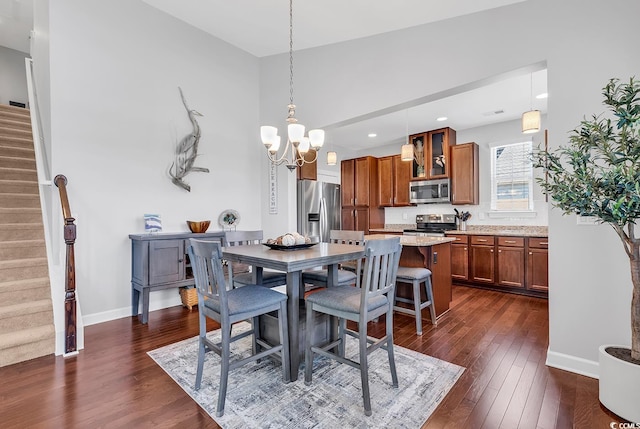 dining room with dark wood-type flooring and an inviting chandelier