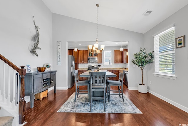 dining area with a notable chandelier, dark hardwood / wood-style floors, and vaulted ceiling