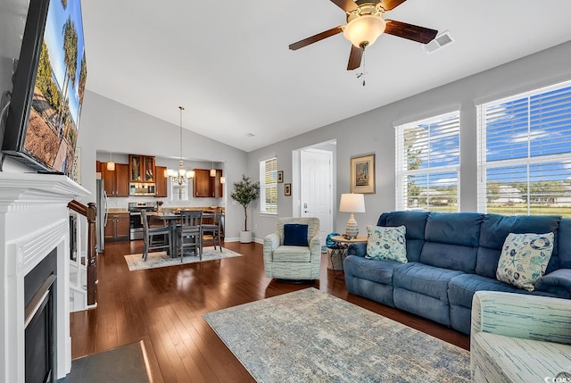 living room featuring lofted ceiling, ceiling fan with notable chandelier, and dark hardwood / wood-style flooring