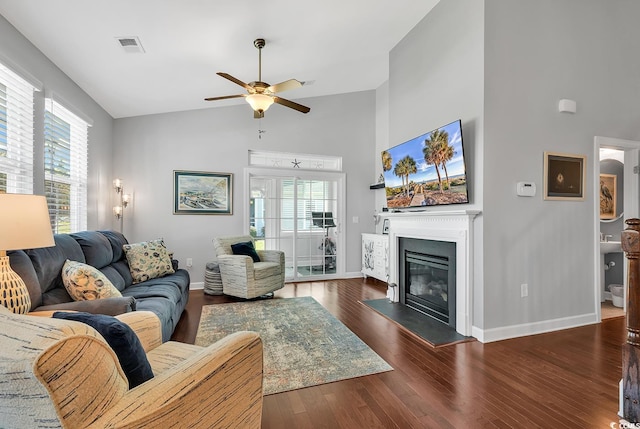 living room with ceiling fan, high vaulted ceiling, and dark hardwood / wood-style flooring