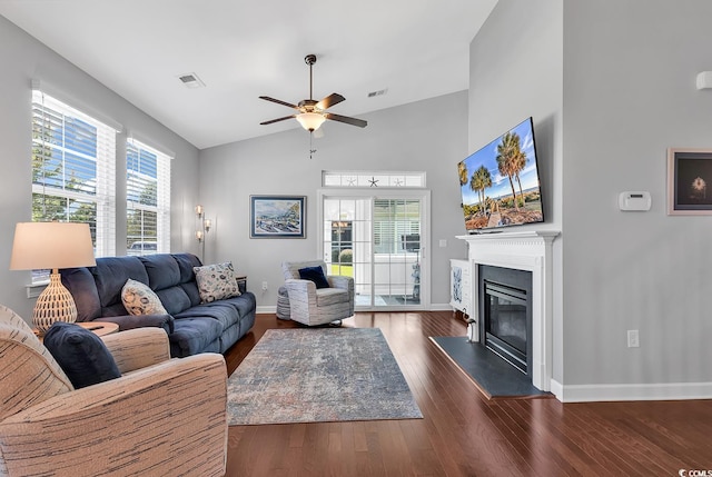 living room featuring ceiling fan, vaulted ceiling, and dark hardwood / wood-style flooring