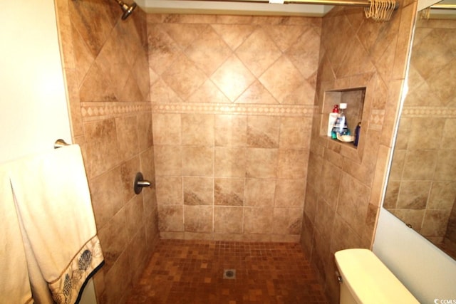 bathroom featuring toilet and a tile shower