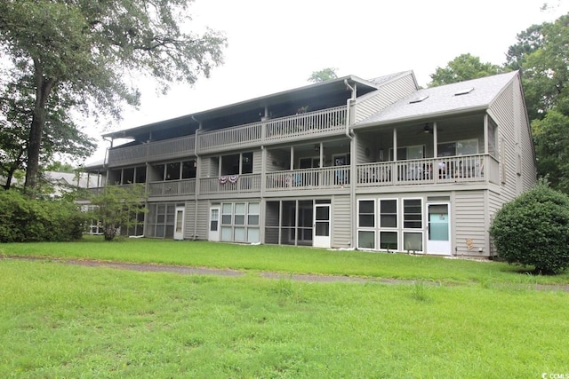 rear view of house with a balcony and a yard