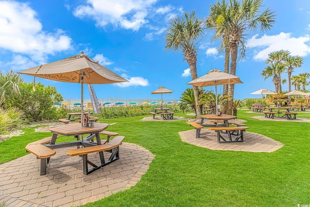 view of home's community featuring a lawn, a patio area, and an outdoor fire pit