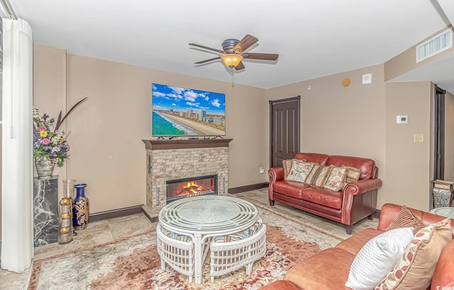 living room with ceiling fan and a stone fireplace