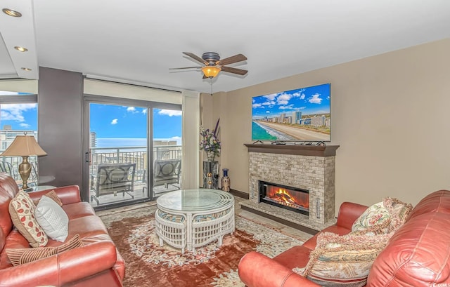 living room featuring ceiling fan and a brick fireplace