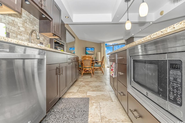 201 74th Ave N Unit 1002, Myrtle Beach, SC 29572 - kitchen with stone tile flooring, stainless steel appliances, a raised ceiling, hanging light fixtures, and light stone countertops