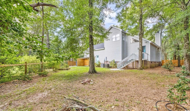 exterior space with central AC, fence, and a chimney