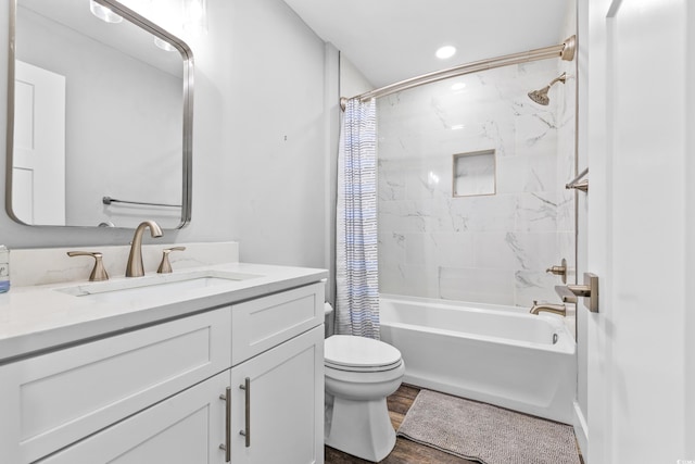 bathroom with wood finished floors, toilet, vanity, and shower / bath combo with shower curtain