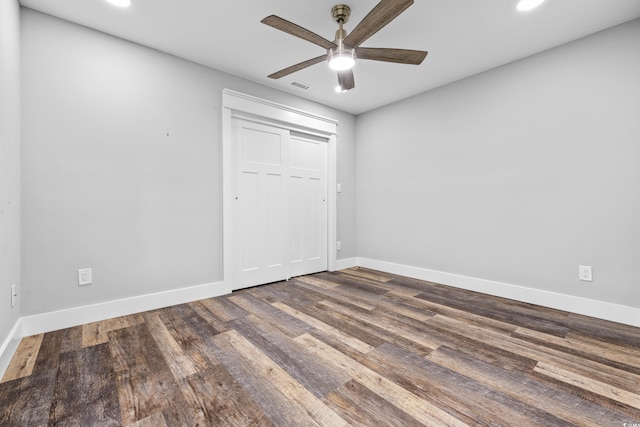 unfurnished bedroom with ceiling fan, a closet, and dark hardwood / wood-style flooring