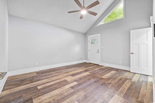 empty room featuring baseboards, high vaulted ceiling, wood finished floors, and a ceiling fan
