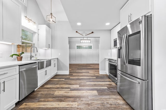 kitchen featuring dark wood-style flooring, stainless steel appliances, tasteful backsplash, white cabinetry, and a sink