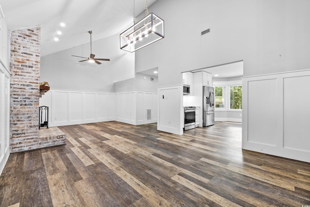 unfurnished living room with ceiling fan, dark hardwood / wood-style floors, and high vaulted ceiling