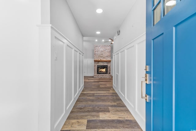 corridor featuring dark wood-type flooring and brick wall