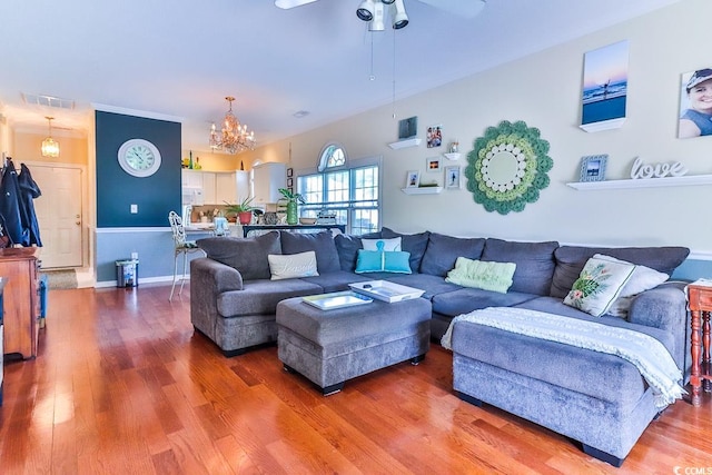 living room featuring ceiling fan with notable chandelier and dark hardwood / wood-style flooring