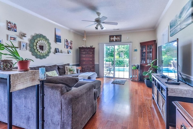 living room with ornamental molding, a textured ceiling, wood-type flooring, and ceiling fan