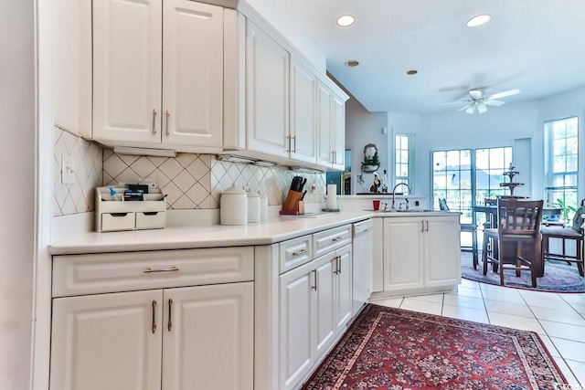 kitchen with light tile patterned floors, tasteful backsplash, sink, white cabinetry, and ceiling fan