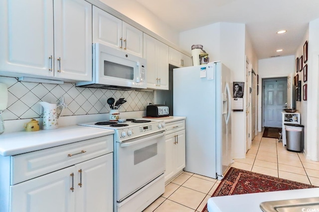 kitchen featuring white appliances, light tile patterned floors, white cabinets, and tasteful backsplash