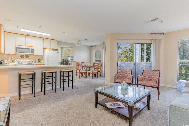 living room featuring ceiling fan and light colored carpet