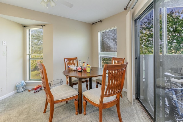 carpeted dining space with ceiling fan