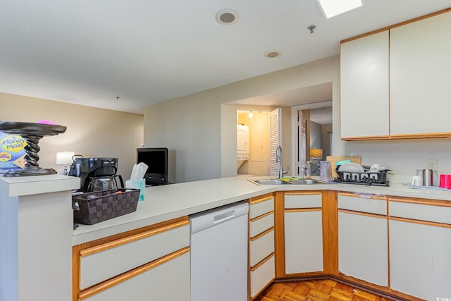 kitchen with white cabinets, sink, kitchen peninsula, dishwasher, and light parquet floors