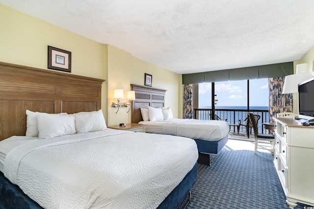 carpeted bedroom featuring a textured ceiling and access to exterior