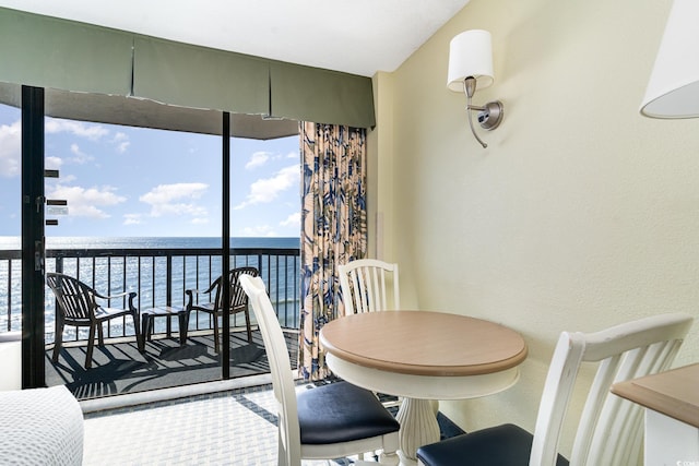 dining room with plenty of natural light, floor to ceiling windows, and a water view