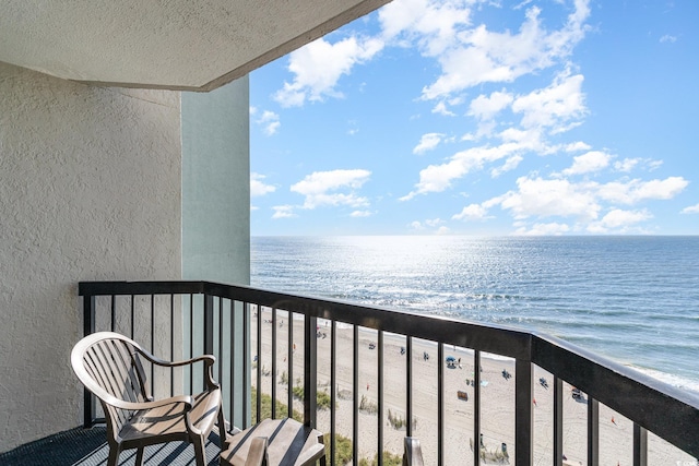 balcony featuring a view of the beach and a water view