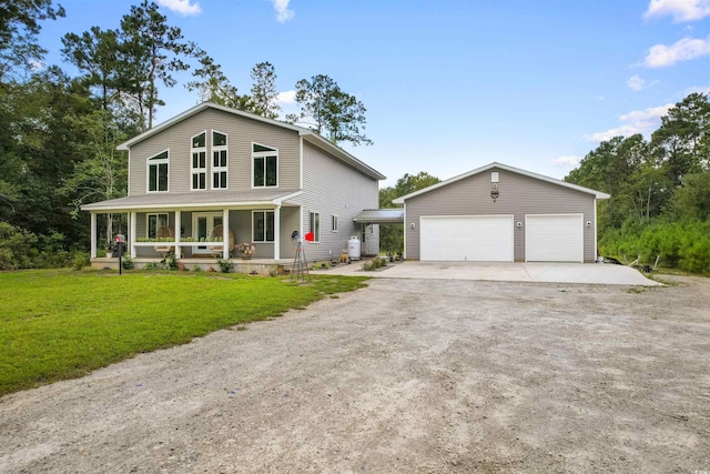 country-style home featuring a porch, a front yard, an outdoor structure, and a detached garage