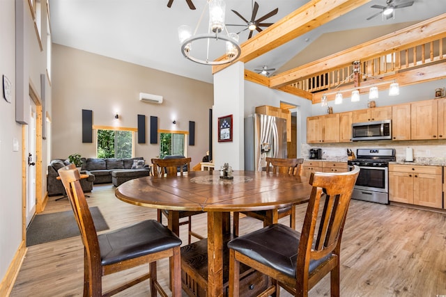 dining space featuring light wood finished floors, ceiling fan with notable chandelier, high vaulted ceiling, and a wall mounted AC