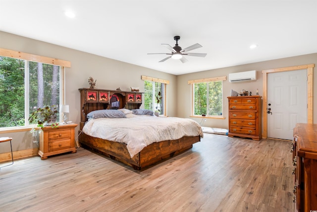 bedroom with a ceiling fan, light wood-type flooring, recessed lighting, and a wall mounted AC