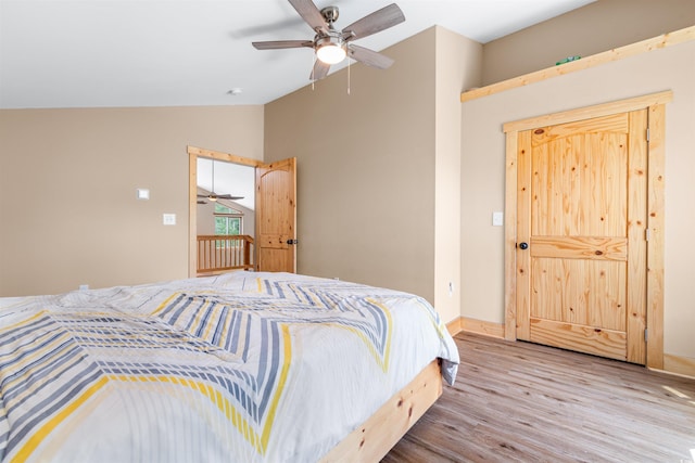 bedroom with vaulted ceiling, ceiling fan, wood finished floors, and baseboards