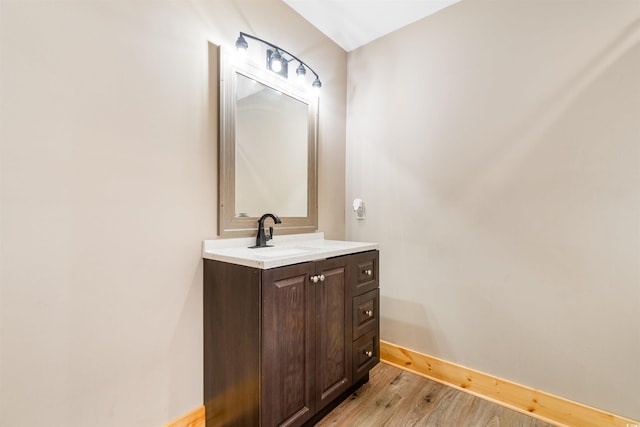 bathroom featuring baseboards, wood finished floors, and vanity