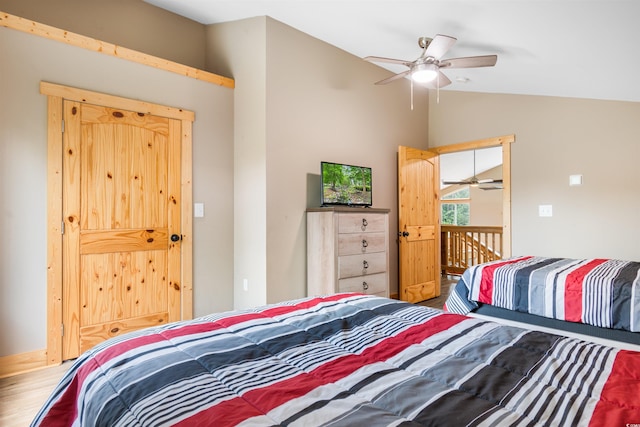 bedroom with ceiling fan, vaulted ceiling, and wood finished floors