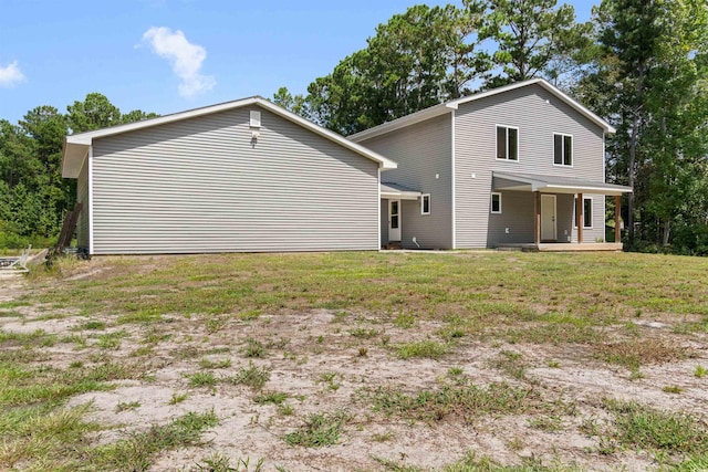 rear view of property with a porch and a lawn