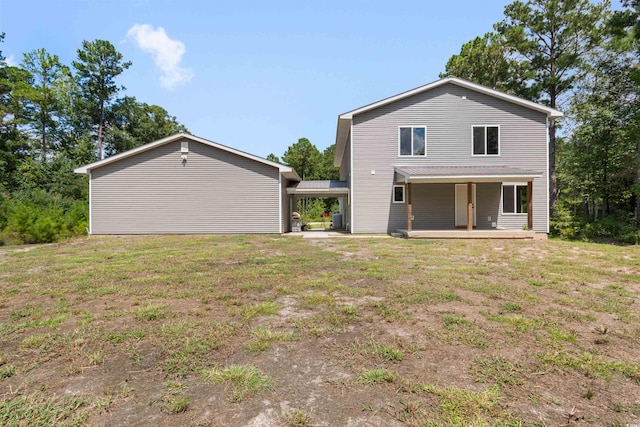 rear view of house with a carport and a lawn