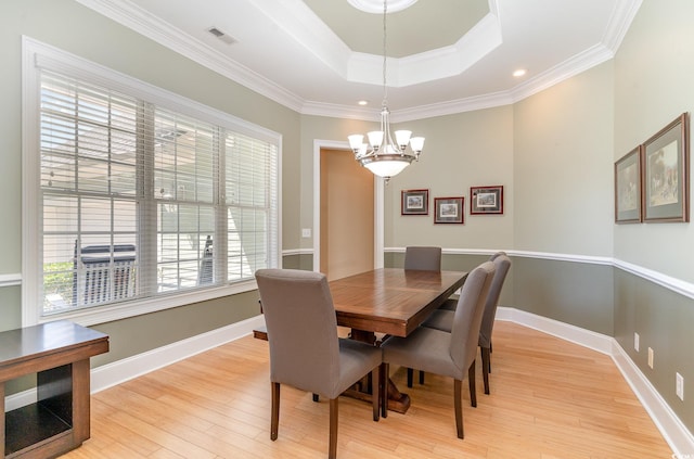 dining space with an inviting chandelier, crown molding, and light hardwood / wood-style flooring