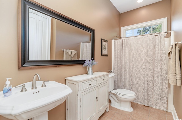 full bathroom with shower / bath combo with shower curtain, tile patterned flooring, sink, and toilet