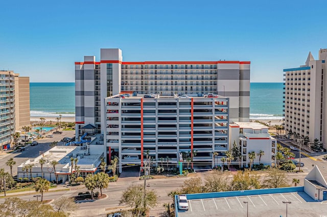 view of building exterior with a water view and a view of the beach