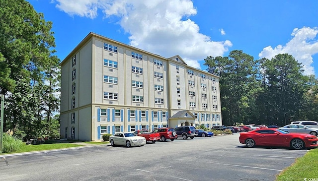 view of building exterior with uncovered parking