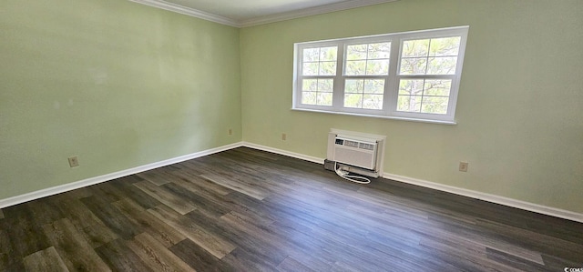 empty room with ornamental molding, a wall mounted AC, dark wood finished floors, and baseboards