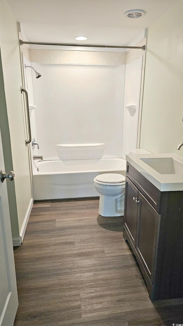 full bath with shower / bathing tub combination, vanity, toilet, and wood finished floors