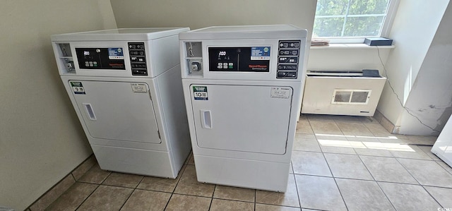 community laundry room with baseboards, washing machine and clothes dryer, and light tile patterned floors